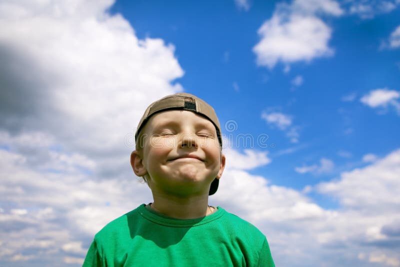 Muchacho despreocupado, sonriente en el cielo azul y nubes blancas Orgulloso y contento consigo mismo, pequeño pilluelo encantado imagenes de archivo Muchacho despreocupado, sonriente en el cielo azul y nubes blancas Orgulloso y contento consigo mismo, pequeño pilluelo encantado imagenes de archivo