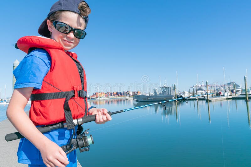Muchacho en la pesca del muelle imagen de archivo