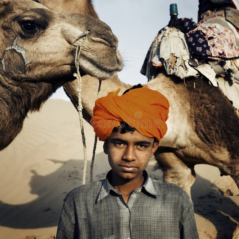 Muchacho indio joven con concepto del desierto de los camellos fotografía de archivo Muchacho indio joven con concepto del desierto de los camellos fotografía de archivo