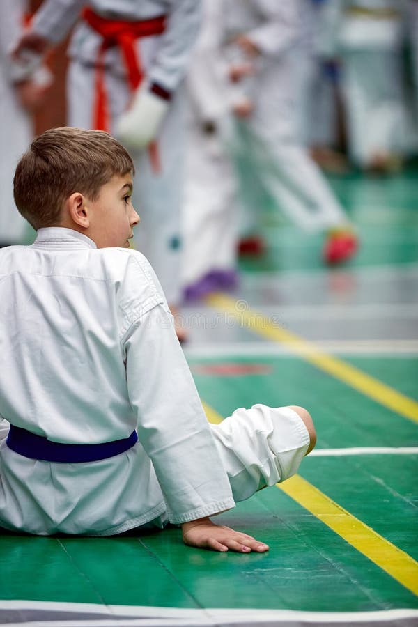 Muchacho joven del karate que calienta en un kimono fotografía de archivo Muchacho joven del karate que calienta en un kimono fotografía de archivo