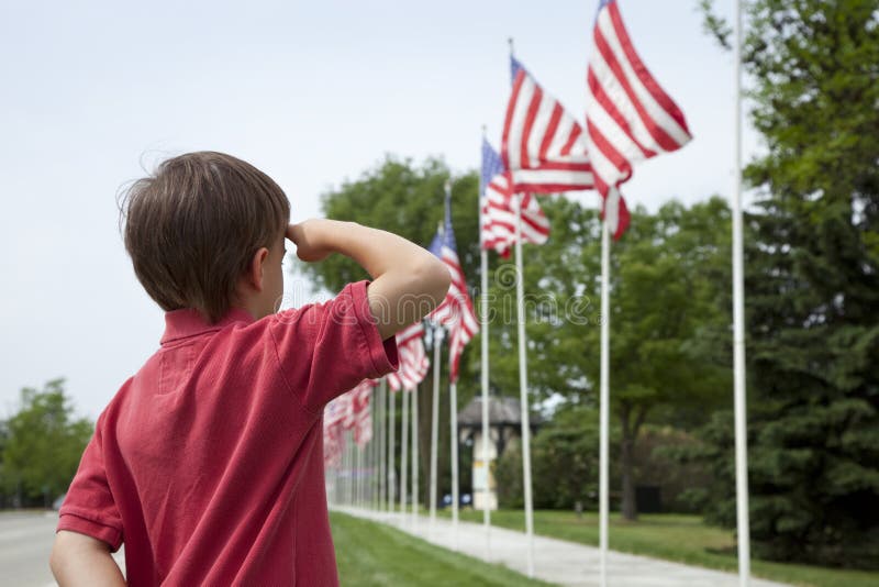 Muchacho joven que saluda indicadores americanos el Memorial Day imagen de archivo libre de regalías