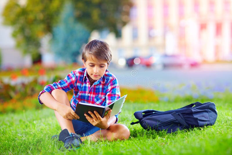 Cute boy, schoolkid reading book in colorful park. Cute boy, schoolkid reading book in colorful park