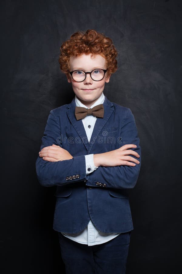 Muchacho listo del niño en vidrios en sala de clase en fondo de la pizarra Retrato elegante del estudiante imagen de archivo libre de regalías Muchacho listo del niño en vidrios en sala de clase en fondo de la pizarra Retrato elegante del estudiante imagen de archivo libre de regalías