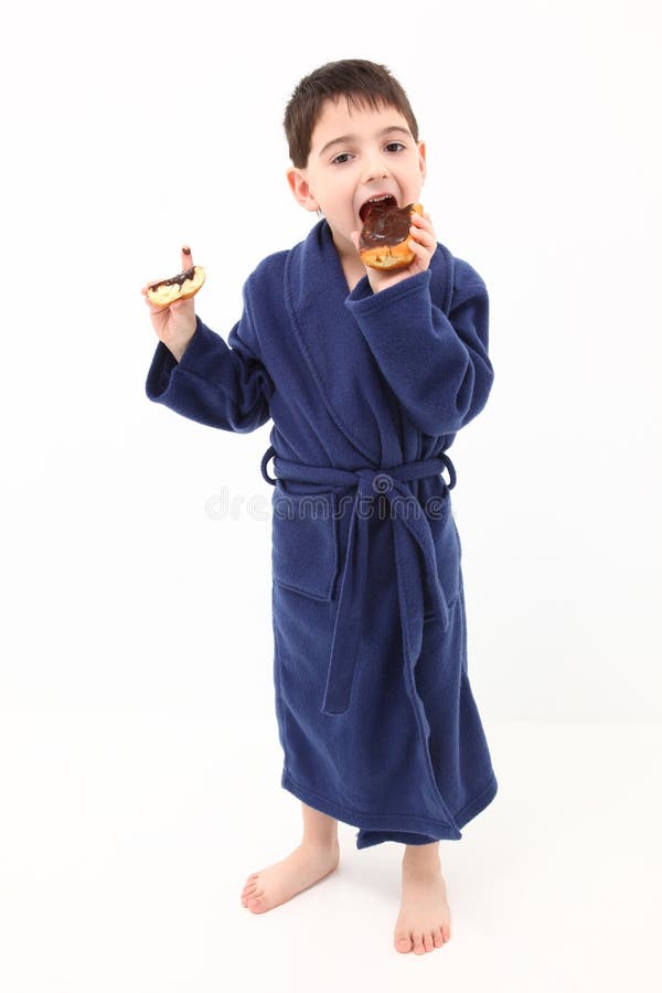 Adorable five year old boy eating a chocolate, bavarian cream filled donut. Adorable five year old boy eating a chocolate, bavarian cream filled donut.