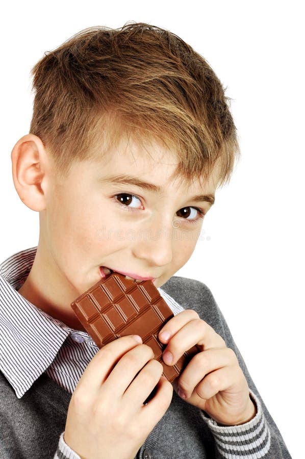 Muchacho que come una barra de chocolate imagen de archivo Muchacho que come una barra de chocolate imagen de archivo