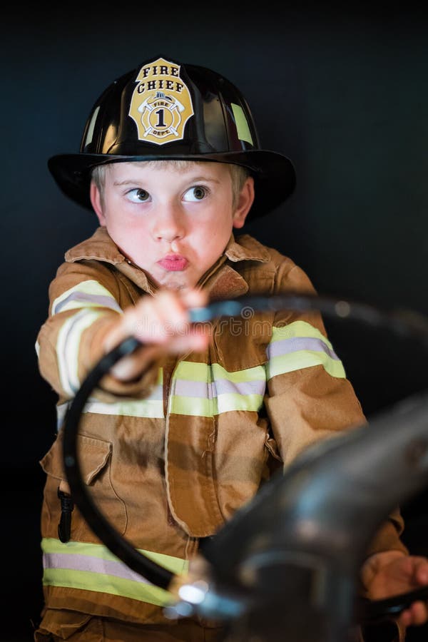 Muchacho que conduce el coche de bomberos imágenes de archivo libres de regalías Muchacho que conduce el coche de bomberos imágenes de archivo libres de regalías