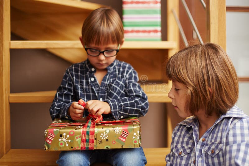 Muchacho que desempaqueta un regalo de Navidad foto de archivo Muchacho que desempaqueta un regalo de Navidad foto de archivo