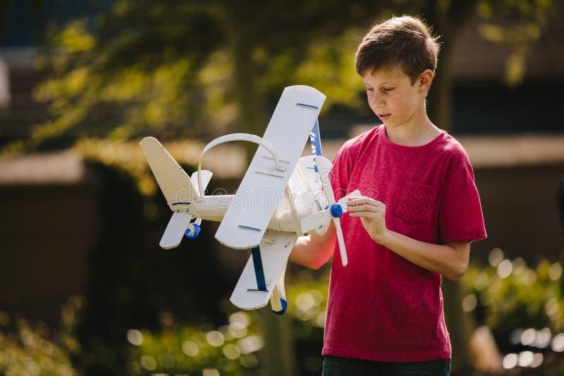 Muchacho que juega con un avión del juguete al aire libre imágenes de archivo libres de regalías Muchacho que juega con un avión del juguete al aire libre imágenes de archivo libres de regalías