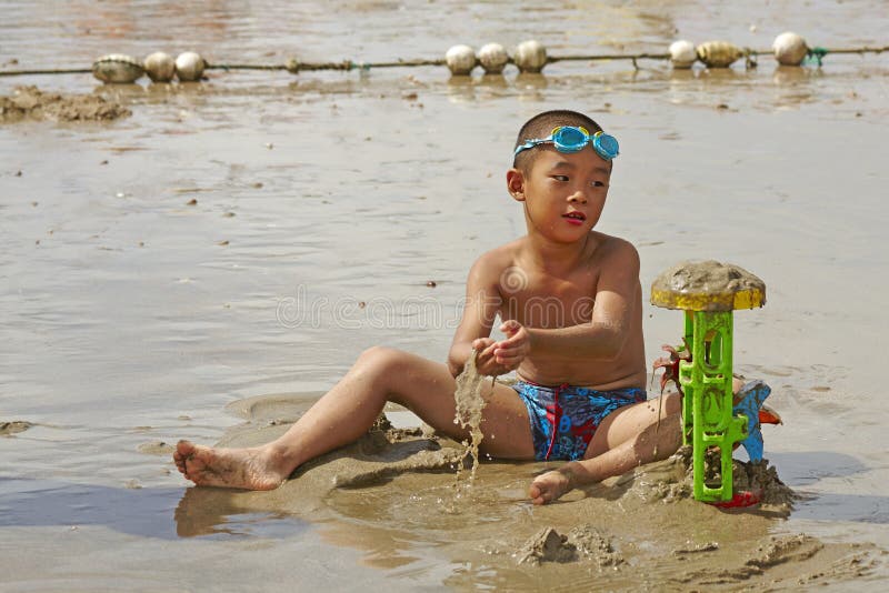 Muchacho que juega las arenas en playa del verano fotos de archivo libres de regalías Muchacho que juega las arenas en playa del verano fotos de archivo libres de regalías