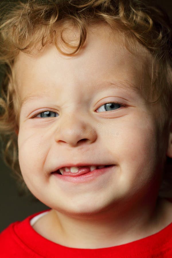 A smiling happy two year old little boy with curly blond hair who has lost a front tooth. Dentist opportunity, Shallow depth of field. A smiling happy two year old little boy with curly blond hair who has lost a front tooth. Dentist opportunity, Shallow depth of field