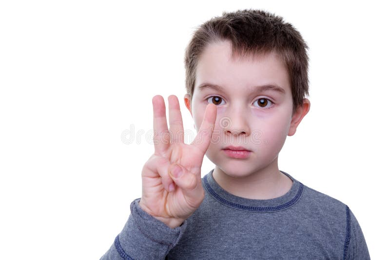 Close up of serious little boy gesturing with three fingers as if to count or display a symbol. Close up of serious little boy gesturing with three fingers as if to count or display a symbol