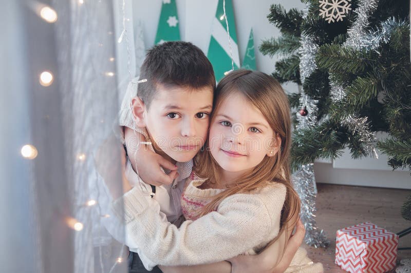 Muchacho y muchacha felices con su regalo de la Navidad La Navidad, día de fiesta y regalos foto de archivo libre de regalías Muchacho y muchacha felices con su regalo de la Navidad La Navidad, día de fiesta y regalos foto de archivo libre de regalías