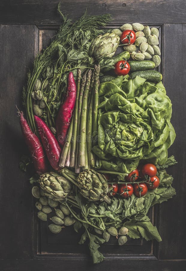 Muchas verduras diferentes. composición sobre fondo oscuro con alcachofa recién cosechada tomates ensalada espárragos rábano imagenes de archivo