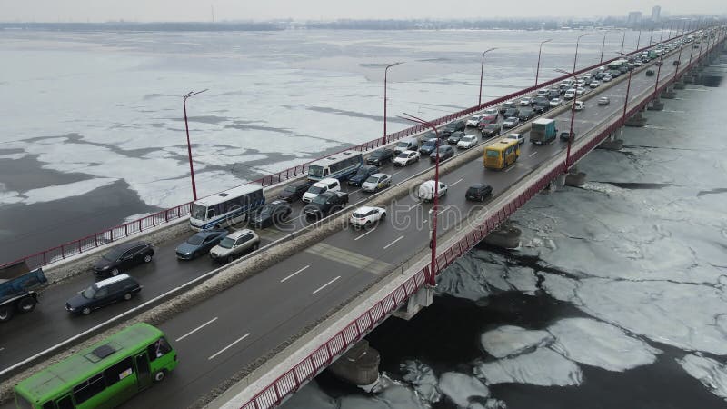 Muchos autos circulan por el puente fluvial en invierno. embotellamiento de tráfico contaminación atmosférica smog en carretera. p