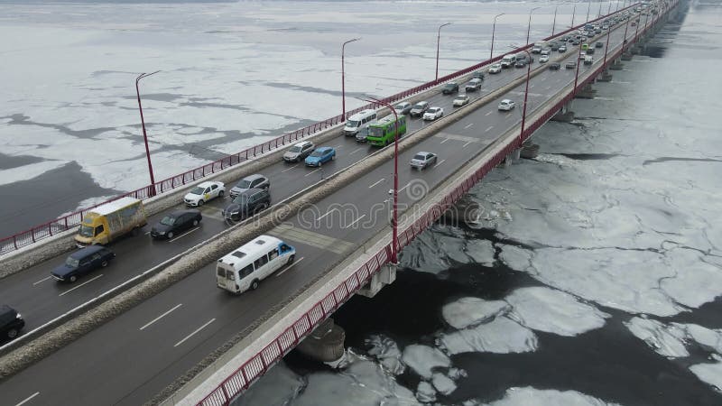 Muchos autos circulan por el puente fluvial en invierno. embotellamiento de tráfico contaminación atmosférica smog en carretera. p