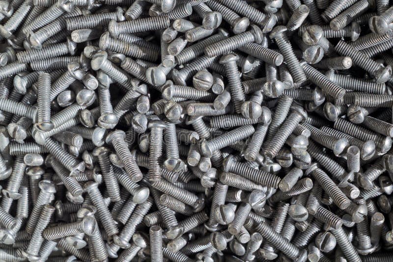 Muchos pequeños tornillos de metal con el hilo y la cabeza ranurada fotografía de archivo libre de regalías Muchos pequeños tornillos de metal con el hilo y la cabeza ranurada fotografía de archivo libre de regalías