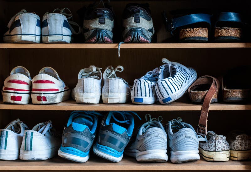 Many old pairs of shoes in a shoe rack, front view. Many old pairs of shoes in a shoe rack, front view.