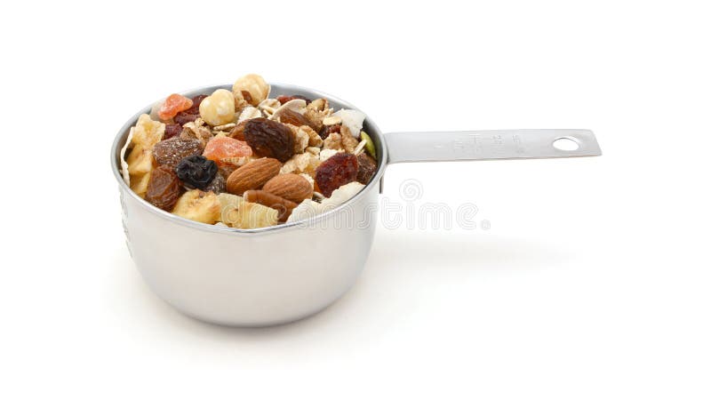 Muesli cereal with fruit and nuts in a measuring cup