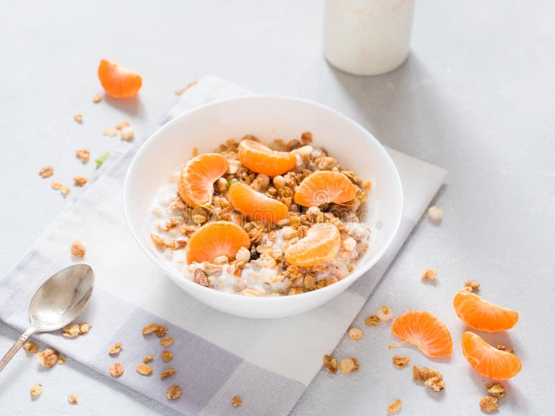 Muesli cocido desayuno sano con las frutas tropicales, las mandarinas frescas y el yogur en el fondo blanco fotos de archivo Muesli cocido desayuno sano con las frutas tropicales, las mandarinas frescas y el yogur en el fondo blanco fotos de archivo
