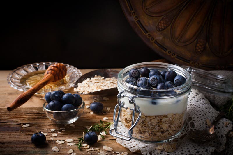 Muesli con el yogur y las bayas azules en el tarro de cristal foto de archivo Muesli con el yogur y las bayas azules en el tarro de cristal foto de archivo