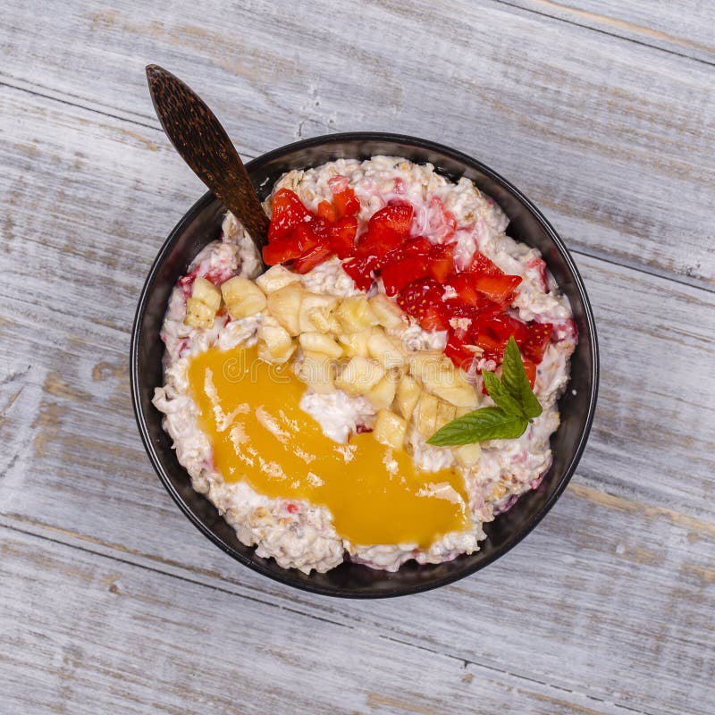 Muesli hizo de las fresas rojas, plátano, semillas del chia, escamas de la avena, miel y se vistió con el yogur fotos de archivo libres de regalías Muesli hizo de las fresas rojas, plátano, semillas del chia, escamas de la avena, miel y se vistió con el yogur fotos de archivo libres de regalías