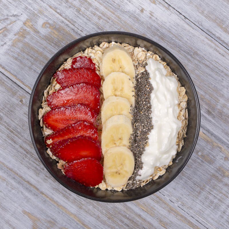 Muesli hizo de las fresas rojas, plátano, semillas del chia, escamas de la avena, miel y se vistió con el yogur imágenes de archivo libres de regalías Muesli hizo de las fresas rojas, plátano, semillas del chia, escamas de la avena, miel y se vistió con el yogur imágenes de archivo libres de regalías