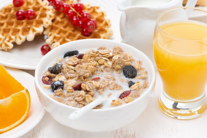 muesli with milk, sweet waffles and orange juice for breakfast