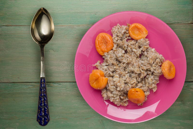 muesli op een rode plaat op een groene houten achtergrond granola met gedroogde abrikozen op een plaat bovenaanzicht stock fotografie muesli op een rode plaat op een groene houten achtergrond granola met gedroogde abrikozen op een plaat bovenaanzicht stock fotografie