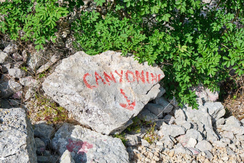 Muestra del descenso de cañones en una piedra, escrita en rojo, apenas sobre el río de Cikola, en Croacia Concepto de la aventura fotos de archivo libres de regalías Muestra del descenso de cañones en una piedra, escrita en rojo, apenas sobre el río de Cikola, en Croacia Concepto de la aventura fotos de archivo libres de regalías