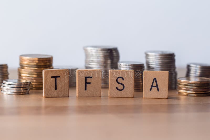 Muestras exentas de impuestos de las cuentas de ahorro de TFSA con las monedas en el fondo imagen de archivo libre de regalías Muestras exentas de impuestos de las cuentas de ahorro de TFSA con las monedas en el fondo imagen de archivo libre de regalías