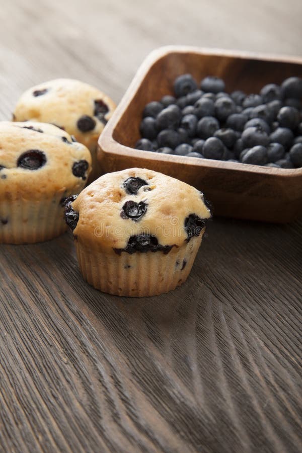 Muffin με τα βακκίνια σε έναν ξύλινο πίνακα φρέσκα μούρα και swe στοκ φωτογραφία