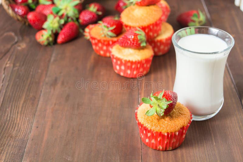Muffins decorated with strawberry and glass of milk stock photography Muffins decorated with strawberry and glass of milk stock photography