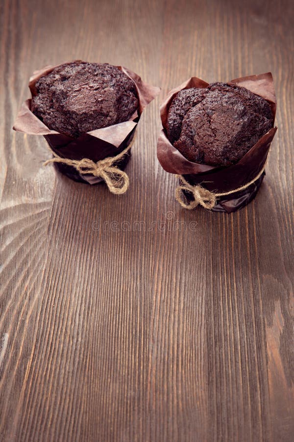 Muffins σοκολάτας στον ξύλινο πίνακα στοκ φωτογραφίες
