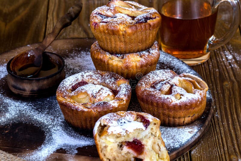 Muffins της Apple με το κύπελλο του μελιού στο ξύλινο υπόβαθρο