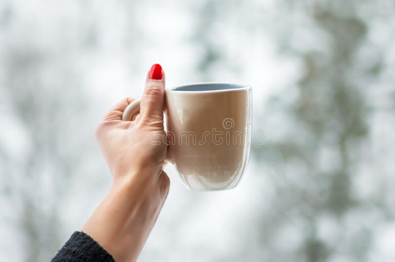 Mug in the hand on snow