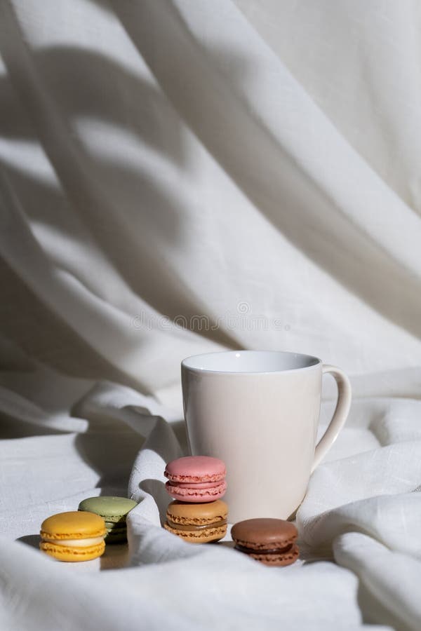 Mug-makaroner och vit duk på den vertikala bakgrundsbilden arkivfoto
