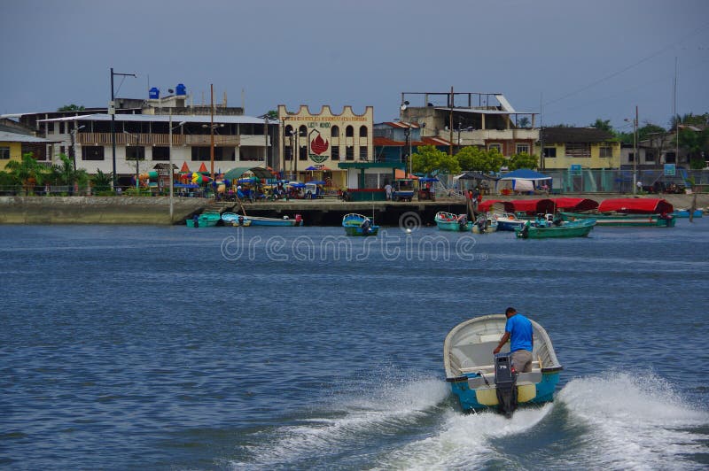 Muisne, Ecuador - March 16, 2016: Man standing inside typical fishing boat crossing water from Muisne to mainland