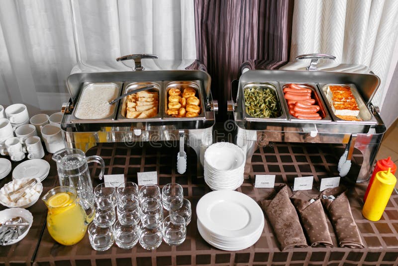 Muitos bofeteiam as bandejas heated prontas para o serviço Café da manhã no bufete da restauração do hotel, recipientes do metal imagem de stock Muitos bofeteiam as bandejas heated prontas para o serviço Café da manhã no bufete da restauração do hotel, recipientes do metal imagem de stock