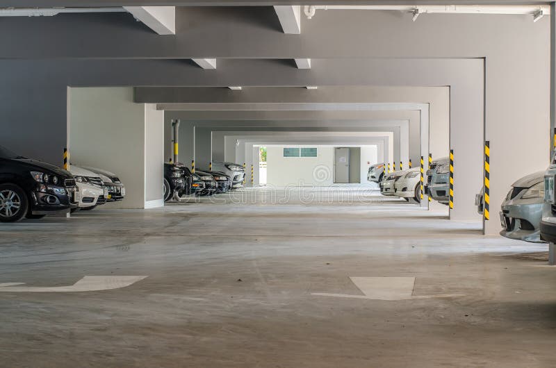 Muitos carros na construção interior da garagem de estacionamento