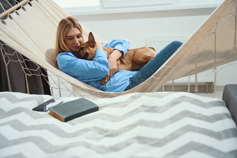 Mujer abrazando a su mascota favorita durante el descanso de la tarde imágenes de archivo libres de regalías