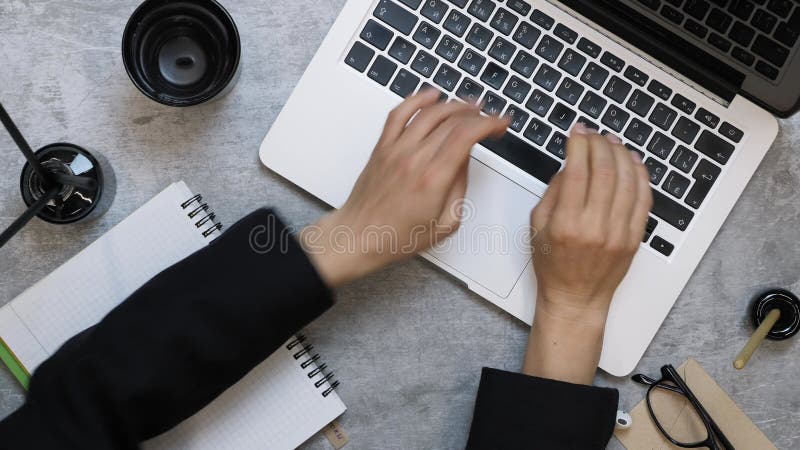 Mujer abriendo computadora laptop y empezando a trabajar en escritorio de trabajo en oficina escribiendo mensajes o cartas de trab