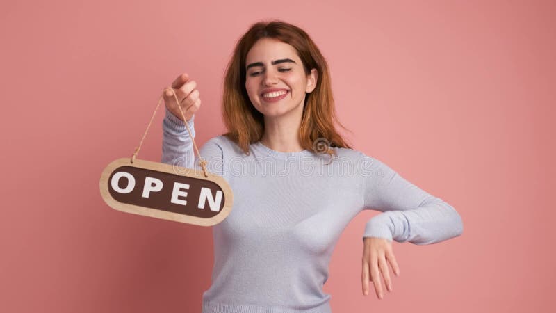 Mujer abriendo un espacio colocando un cartel metrajes