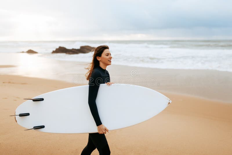 Mujer Activa Caminando Con Tablas De Surf En El Agua Con Expresión Vestida Con Ropa Especial Para Surfear Imagen de archivo - Imagen de 276766701