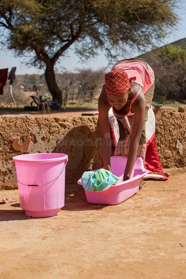 Mujer africana de recoger la ropa sucia Fotografía de stock - Alamy