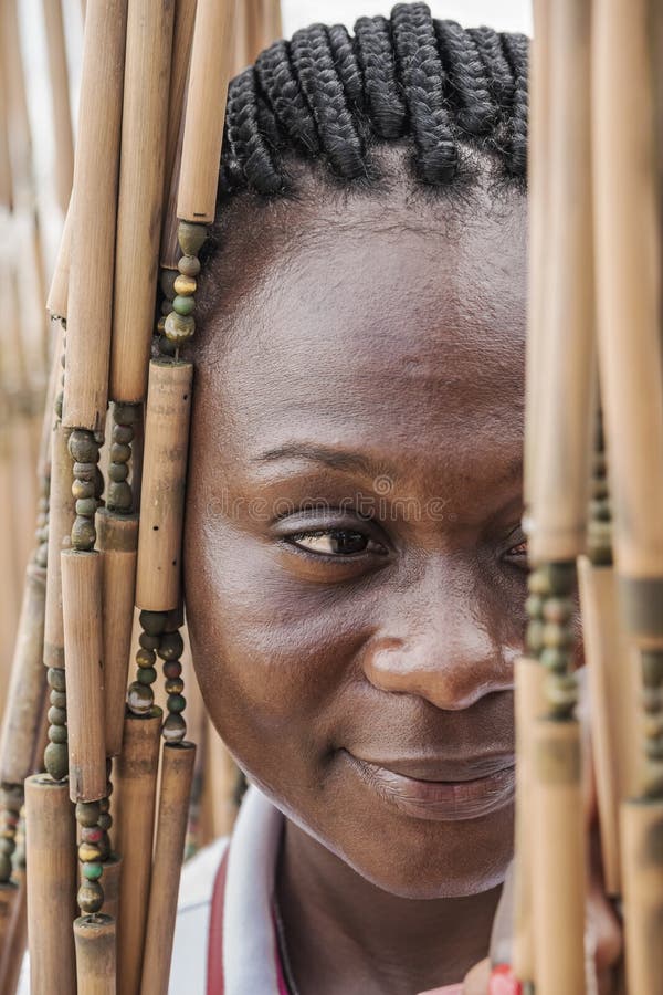 Mujer africana mirando a través de una cortina de bambú. Mujer africana mirando hacia afuera a través de una cortina de bambú en accra, ghana
