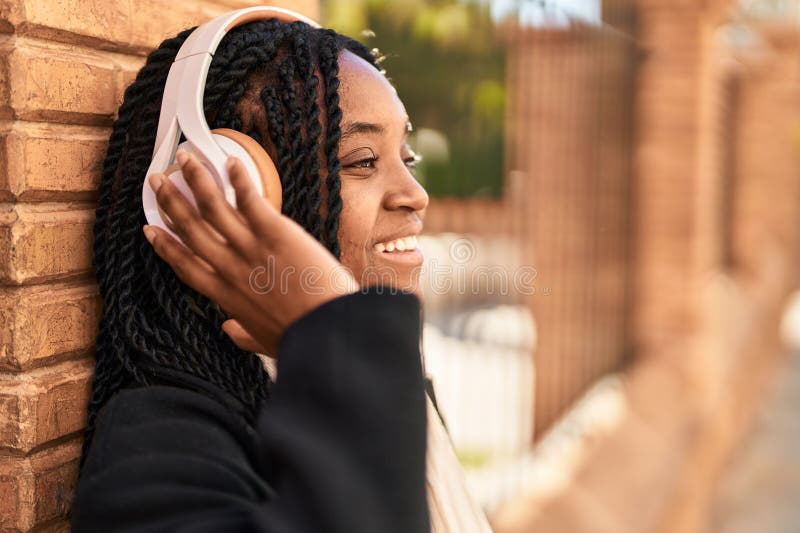 Mujer afroamericana escuchando música en la calle imagen de archivo