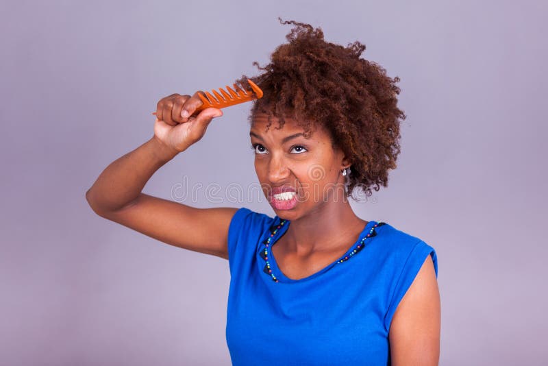 Mujer afroamericana joven que se peina el pelo afro muy rizado - Blac