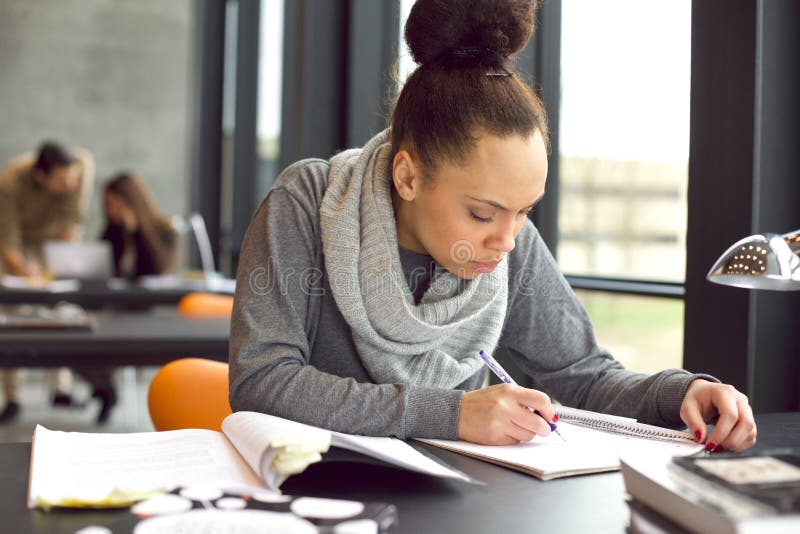 Mujer afroamericana joven que toma notas foto de archivo Mujer afroamericana joven que toma notas foto de archivo