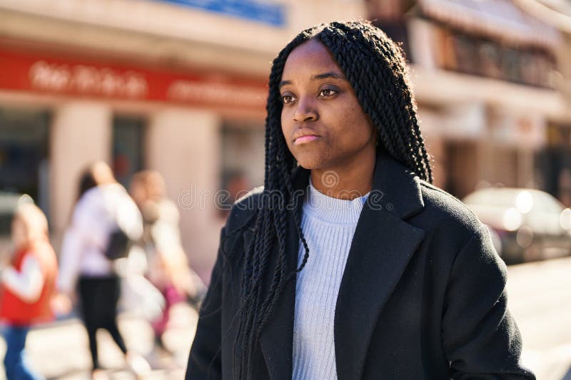 Mujer afroamericana mirando al lado con expresión seria en la calle foto de archivo libre de regalías