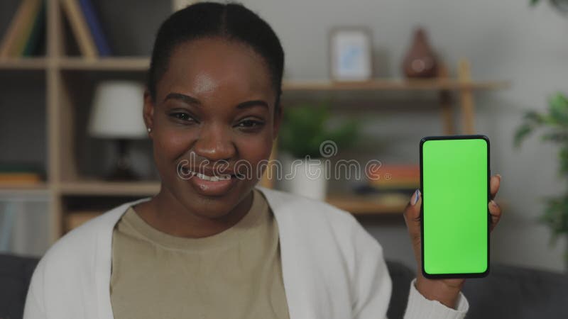 Mujer afroamericana mostrando el teléfono con la pantalla con llave croma metrajes